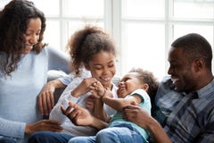Familia afroamericana feliz que juega con los niños en casa imágenes de archivo libres de regalías Familia afroamericana feliz que juega con los niños en casa imágenes de archivo libres de regalías