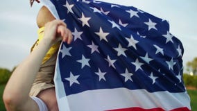 Familia americana feliz en una comida campestre el 4 de julio Juegos de abuelo con el nieto El bebé se sienta en los hombros de l almacen de video Familia americana feliz en una comida campestre el 4 de julio Juegos de abuelo con el nieto El bebé se sienta en los hombros de l almacen de video