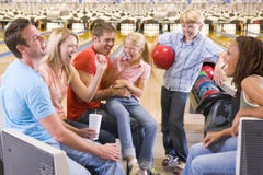 Familia en callejón de bowling con animar de dos amigos Familia en callejón de bowling con animar de dos amigos