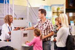 Familia en el escritorio del incorporar del aeropuerto que se va el vacaciones imagen de archivo libre de regalías Familia en el escritorio del incorporar del aeropuerto que se va el vacaciones imagen de archivo libre de regalías