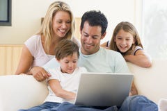 Familia en sala de estar con la sonrisa de la computadora portátil Familia en sala de estar con la sonrisa de la computadora portátil
