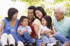 Familia extensa que sienta al aire libre la sonrisa imagen de archivo Familia extensa que sienta al aire libre la sonrisa imagen de archivo