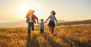 Familia feliz: madre, padre, niños hijo e hija en sunse Fotos de archivo libres de regalías Familia feliz: madre, padre, niños hijo e hija en sunse Fotos de archivo libres de regalías