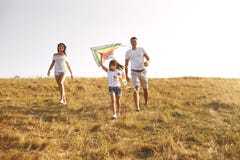 Familia feliz que camina en naturaleza en la puesta del sol en verano imagenes de archivo Familia feliz que camina en naturaleza en la puesta del sol en verano imagenes de archivo