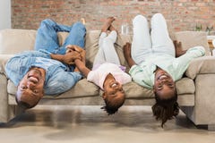 Familia feliz que se relaja en el sofá foto de archivo Familia feliz que se relaja en el sofá foto de archivo