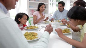 Familia india de la generación multi que come la comida en casa almacen de video Familia india de la generación multi que come la comida en casa almacen de video