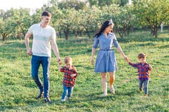 Familia joven feliz que pasa el tiempo junto afuera en naturaleza verde Padres que juegan con los gemelos afuera imagen de archivo libre de regalías Familia joven feliz que pasa el tiempo junto afuera en naturaleza verde Padres que juegan con los gemelos afuera imagen de archivo libre de regalías