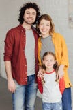familia joven feliz que se une y que sonríe fotografía de archivo libre de regalías familia joven feliz que se une y que sonríe fotografía de archivo libre de regalías