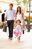 Familia joven que disfruta de viaje de las compras imagen de archivo libre de regalías Familia joven que disfruta de viaje de las compras imagen de archivo libre de regalías