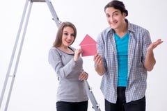 Familia joven que hace la renovación en casa fotografía de archivo libre de regalías Familia joven que hace la renovación en casa fotografía de archivo libre de regalías