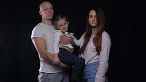 Familia llena feliz, padre que detiene a su hija, situación de la madre al lado de ellos almacen de video Familia llena feliz, padre que detiene a su hija, situación de la madre al lado de ellos almacen de video