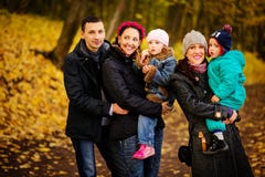 Familia que camina con dos niños en parque otoñal imagen de archivo Familia que camina con dos niños en parque otoñal imagen de archivo