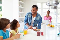 Familia que desayuna en cocina junto fotos de archivo Familia que desayuna en cocina junto fotos de archivo