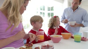 Familia que desayuna en cocina junto almacen de metraje de vídeo Familia que desayuna en cocina junto almacen de metraje de vídeo