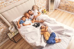 Familia que duerme junto en cama fotografía de archivo Familia que duerme junto en cama fotografía de archivo