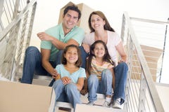 Familia que se sienta en escalera con los rectángulos en nuevo hogar Familia que se sienta en escalera con los rectángulos en nuevo hogar