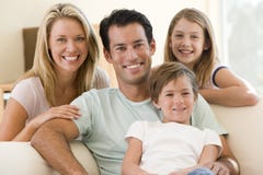 Familia que se sienta en la sonrisa de la sala de estar Familia que se sienta en la sonrisa de la sala de estar