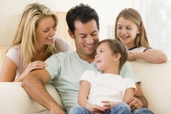 Familia que se sienta en la sonrisa de la sala de estar Familia que se sienta en la sonrisa de la sala de estar
