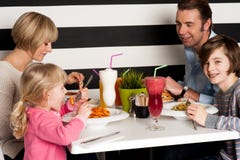 Familia que tuesta los smoothies en restaurante fotos de archivo libres de regalías Familia que tuesta los smoothies en restaurante fotos de archivo libres de regalías