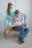 Familia unida agradable de mamá, de papá y de hija presentando en su sitio blanco fotografía de archivo libre de regalías Familia unida agradable de mamá, de papá y de hija presentando en su sitio blanco fotografía de archivo libre de regalías