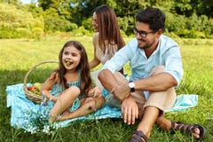 Familie auf Picknick Glückliche junge Familie, die Spaß in der Natur hat lizenzfreie stockfotos Familie auf Picknick Glückliche junge Familie, die Spaß in der Natur hat lizenzfreie stockfotos