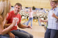 Familie in der Bowlingbahn zujubelnd und lächelnd Familie in der Bowlingbahn zujubelnd und lächelnd
