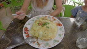 Familie, die eine traditionelle malaysische und indonesische Nahrung - nasi goreng eingewickelt in einem Spiegelei isst Reise nac stock video footage Familie, die eine traditionelle malaysische und indonesische Nahrung - nasi goreng eingewickelt in einem Spiegelei isst Reise nac stock video footage