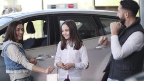Familie, die einen Neuwagen kaufend feiert Familie, die einen Neuwagen kaufend feiert