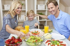 Familie, die gesunde Nahrung u. Salat an Speisetische isst stockbilder Familie, die gesunde Nahrung u. Salat an Speisetische isst stockbilder