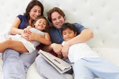 Familie, die im Bett mit Kaffee und Zeitung sich entspannt stockfoto Familie, die im Bett mit Kaffee und Zeitung sich entspannt stockfoto