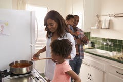 Familie die thuis Maaltijd in Keuken samen voorbereiden royalty-vrije stock afbeeldingen Familie die thuis Maaltijd in Keuken samen voorbereiden royalty-vrije stock afbeeldingen