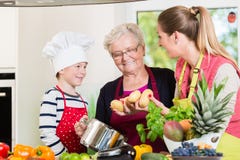 Familie het koken in multigenerationeel huishouden met zoon, moeder, royalty-vrije stock afbeelding Familie het koken in multigenerationeel huishouden met zoon, moeder, royalty-vrije stock afbeelding