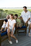 Familie van vier die samen in openlucht op terrac zitten stock afbeelding Familie van vier die samen in openlucht op terrac zitten stock afbeelding