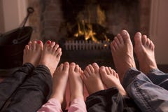 Familie van voeten die bij een open haard verwarmen stock afbeeldingen Familie van voeten die bij een open haard verwarmen stock afbeeldingen