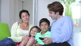 Familiezitting op Sofa Watching-TV samen stock video Familiezitting op Sofa Watching-TV samen stock video