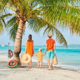 Familj av tre p? stranden under palmtr?det arkivbild Familj av tre p? stranden under palmtr?det arkivbild