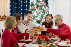 Familj med ungar som har julmatställen på trädet royaltyfri fotografi Familj med ungar som har julmatställen på trädet royaltyfri fotografi