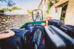 Familj som rider en traktorsläp med resväskor och bagage royaltyfria foton Familj som rider en traktorsläp med resväskor och bagage royaltyfria foton
