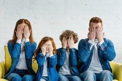 Familj som sitter på soffan och att täcka arkivfoto Familj som sitter på soffan och att täcka arkivfoto