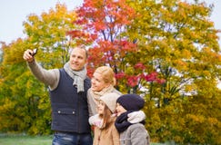 Familjen som tar selfie vid smartphonen i höst, parkerar arkivbild Familjen som tar selfie vid smartphonen i höst, parkerar arkivbild