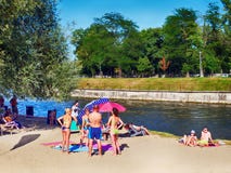 Familjer med barn som solbadar på flodbankerna Royaltyfria Bilder Familjer med barn som solbadar på flodbankerna Royaltyfria Bilder