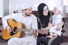 Famille du Moyen-Orient joyeuse jouant la guitare photographie stock libre de droits Famille du Moyen-Orient joyeuse jouant la guitare photographie stock libre de droits