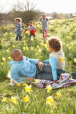 Famille détendant dans le domaine des jonquilles de source images stock Famille détendant dans le domaine des jonquilles de source images stock