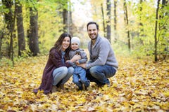 Famille heureuse détendant dehors en parc d'automne Photo stock Famille heureuse détendant dehors en parc d'automne Photo stock