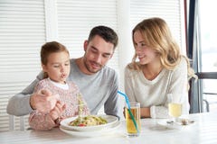 Famille heureuse dînant au restaurant ou au café photographie stock libre de droits Famille heureuse dînant au restaurant ou au café photographie stock libre de droits