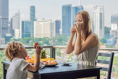 Famille heureuse prenant le petit déjeuner sur le balcon Table de petit déjeuner avec le fruit et le pain de café croisant sur un photo libre de droits Famille heureuse prenant le petit déjeuner sur le balcon Table de petit déjeuner avec le fruit et le pain de café croisant sur un photo libre de droits