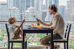 Famille heureuse prenant le petit déjeuner sur le balcon Table de petit déjeuner avec le fruit et le pain de café croisant sur un images libres de droits Famille heureuse prenant le petit déjeuner sur le balcon Table de petit déjeuner avec le fruit et le pain de café croisant sur un images libres de droits