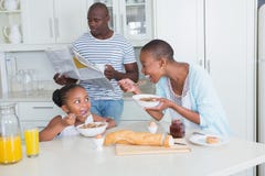 Famille heureuse reposant et prenant le petit déjeuner image libre de droits Famille heureuse reposant et prenant le petit déjeuner image libre de droits