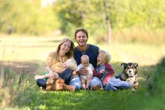 Famille heureuse riant ainsi que le chien dehors photos libres de droits Famille heureuse riant ainsi que le chien dehors photos libres de droits