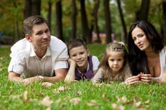 Famille heureux se couchant dans le jardin image stock Famille heureux se couchant dans le jardin image stock